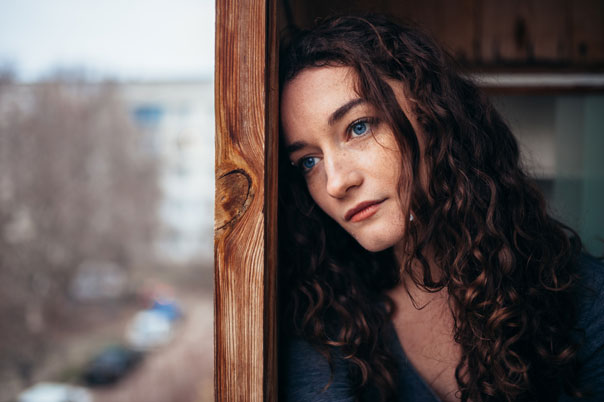 Curly haired lonely woman in blue shirt