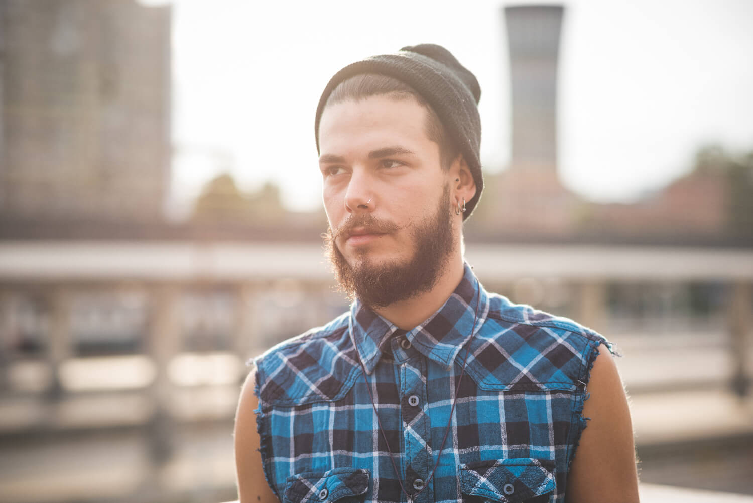 Bearded man outside with cutoff shirt and stocking cap on