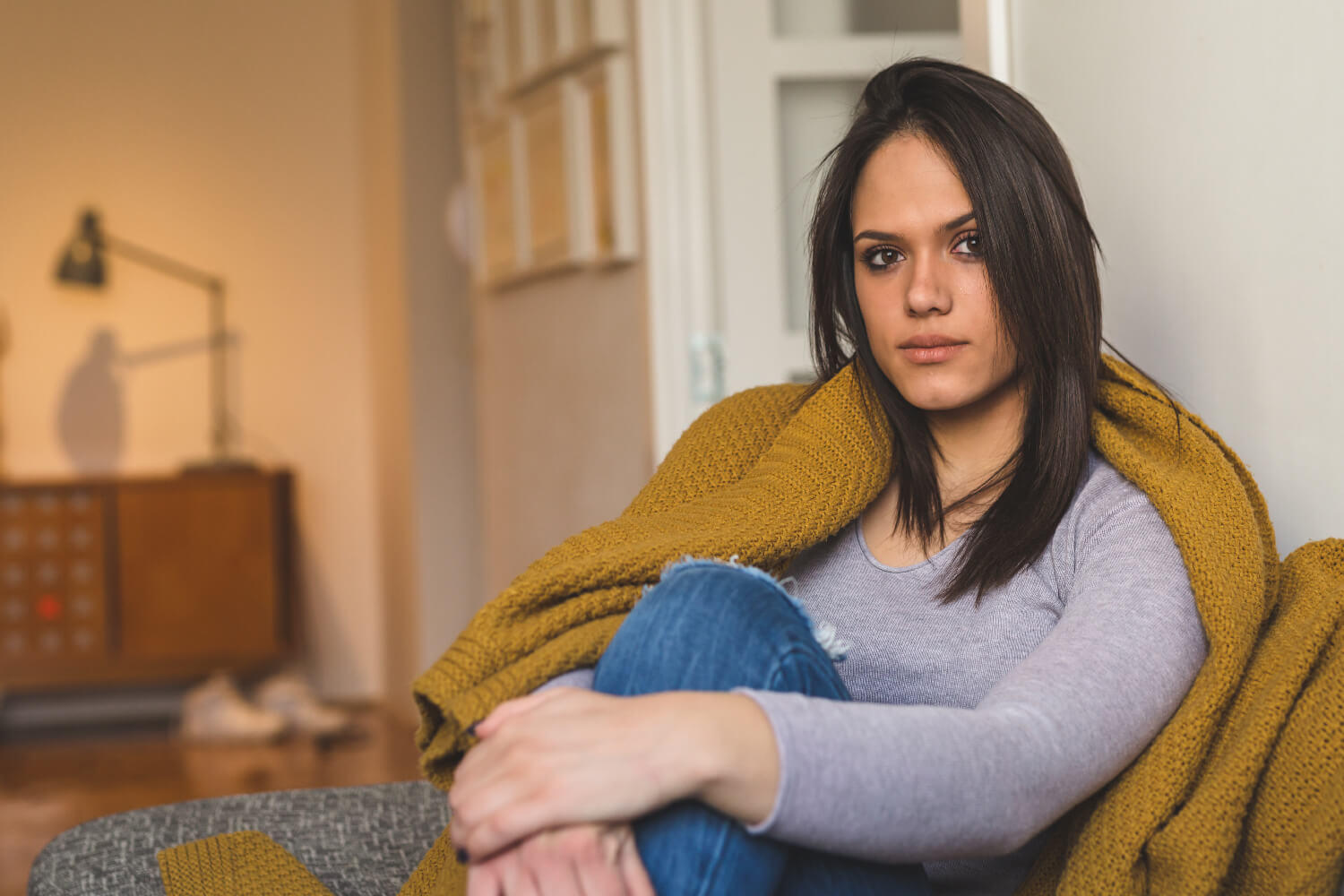 Woman sitting on a couch with a blanket