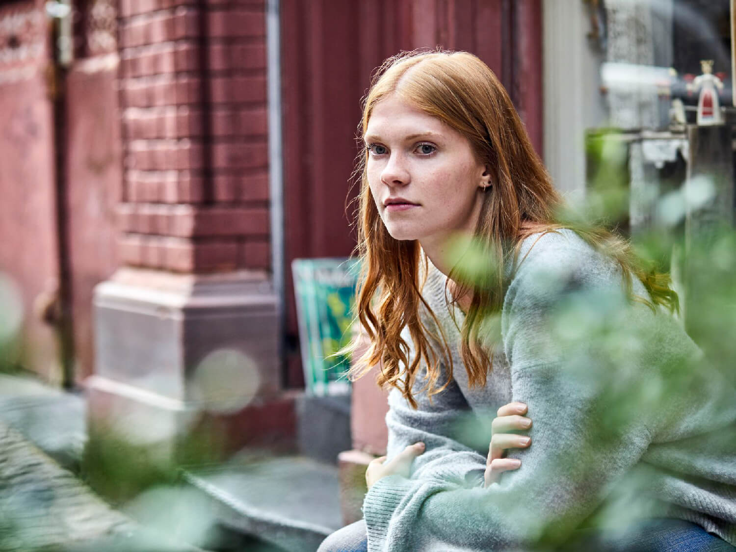 Woman sitting alone outside of a building on steps